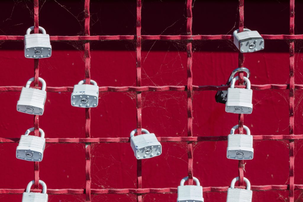 Red metal fence with padlocks attached